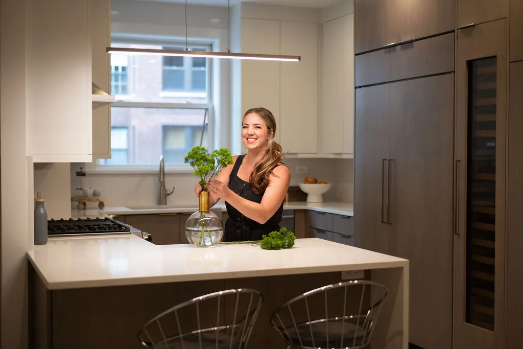 Herb-Admiring-Kitchen-Scene Contemporary powder room with geometric wallpaper, sleek marble countertop, and contrasting elements. Elegant pendant lighting enhances the modern aesthetic.