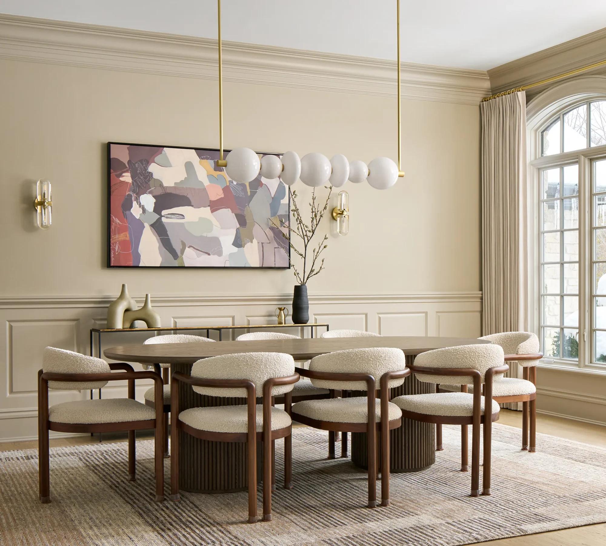 Modern dining room with beige palette, geometric chandelier, and stylish decor.